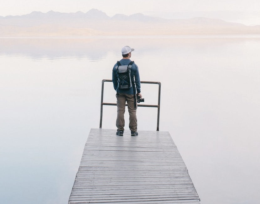 Man standing near the edge of a lake