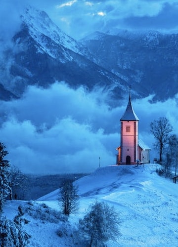 A church in the middle of snowy mountainous landscape